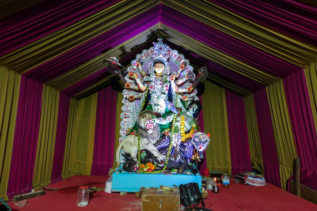 Colorful statue of Goddess Durga during a vibrant Indian festival indoors.